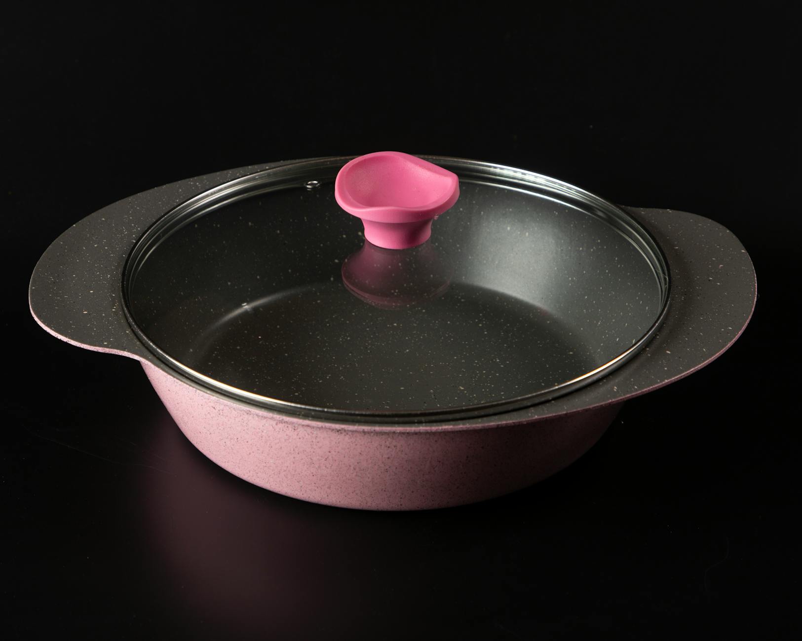 Stylish pink ceramic cooking pan with glass lid, perfect for modern kitchens.